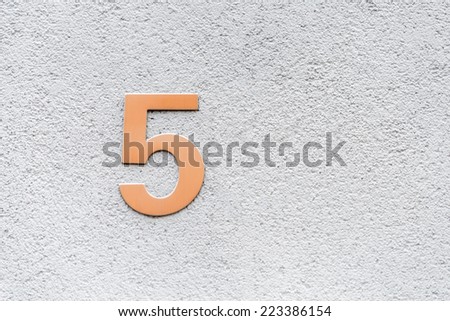 Image of the number 5 on a concrete wall indicating a house number