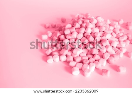 Color of year 2023 Viva Magenta. Image with small round marshmallows is toned in pantone color of viva magenta. New Fashion colour. Pile of twisted marshmallows. Side view. Sweets