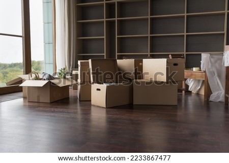 Heap of paper boxes for moving with household stuff stacked on floor in room with nobody. Relocation objects in new empty apartment. Cargo, containers delivered into new house for unpacking Royalty-Free Stock Photo #2233867477