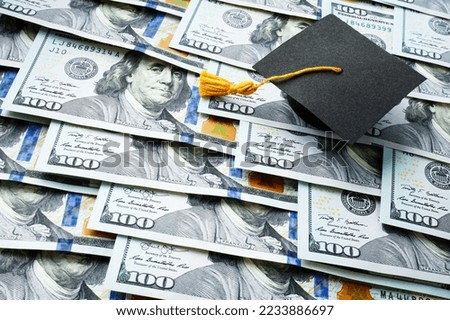 Graduation cap on the stack of money. Student loan concept. Royalty-Free Stock Photo #2233886697