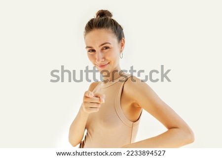 Young beautiful woman wearing tank top laughing at you, pointing index finger at camera showing shame, mocking expression, sneering and pranking, joking, isolated on white background Royalty-Free Stock Photo #2233894527