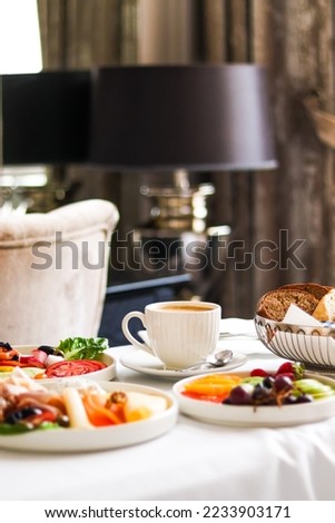 Luxury hotel and five star room service, various food platters, bread and coffee as in-room breakfast for travel and hospitality brand Royalty-Free Stock Photo #2233903171