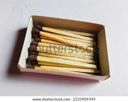 matchsticks isolated on white background. Macro photography. Close-up shot. Matches in open match-box on carton underlay.