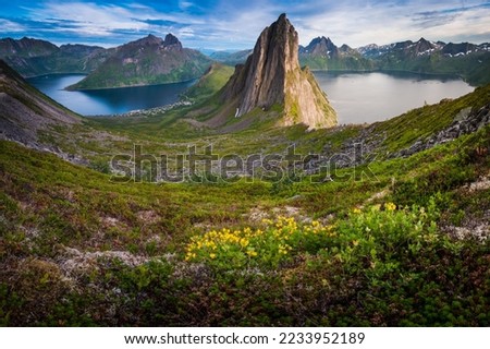 Stunning summer landscape from Mount Hesten on Iconic Mountain Segla in late evening light. Clear fjord waters and mountain range in background, Fjordgard, Senja, Norway Royalty-Free Stock Photo #2233952189