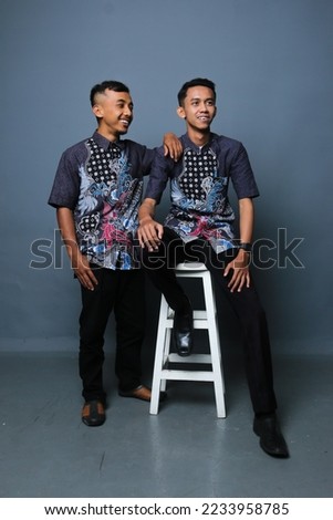 two men from asia posing in various styles for the camera on a gray background