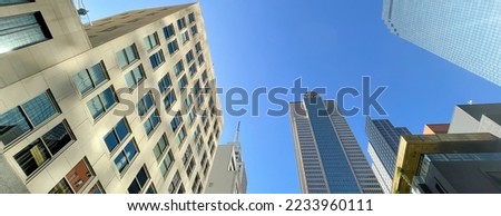 Panorama lookup view skyscrapers and corporate office buildings under clear blue sky along Main Street in Downtown Dallas, TX, USA. Wide angle upward perspective of high-rise tower in metro complex