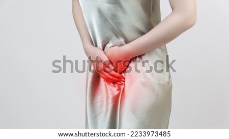 Menstrual pain, woman with stomachache suffering from pms , endometriosis, cystitis and other diseases of the urinary system, painful area highlighted in red Royalty-Free Stock Photo #2233973485