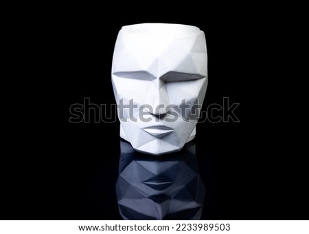 support as a vase, focus in front. plaster vase in the shape of a face on a black background. isolated