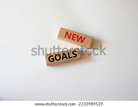 New goals symbol. Wooden blocks with words New goals. Beautiful white background. Business and New goals concept. Copy space.