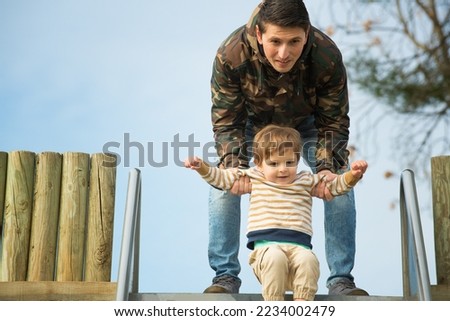 Father and son on a slide in a park
