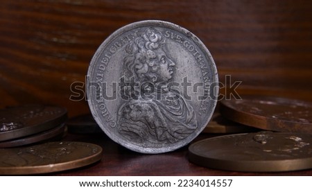 Antique commemorative medal 17th century Swedish king Charles 11 against the background of old European medals abstraction selective focus