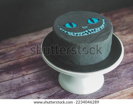 black matte edible paint on frosted spongy birthday cake with bad cat printed topper isolated on studio