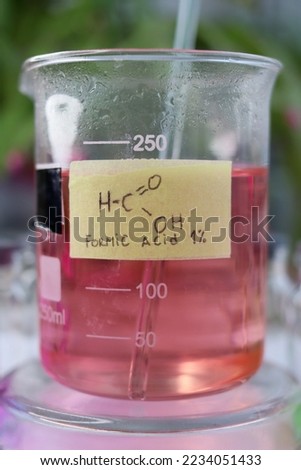 Weakly concentrated aqueous solution of strong organic formic acid, colored with the indicator dye methyl orange.