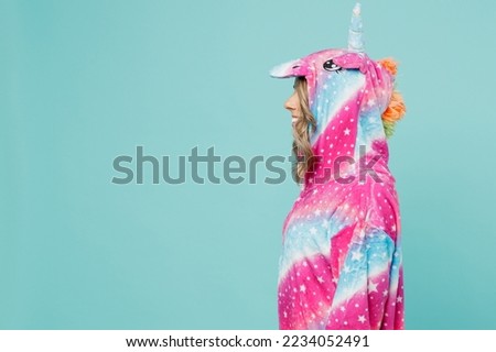 Young side profile view woman 20s she wearing pink domestic costume with hoody and animals ears going to bed look aside isolated on plain pastel light blue cyan background. People lifestyle concept Royalty-Free Stock Photo #2234052491