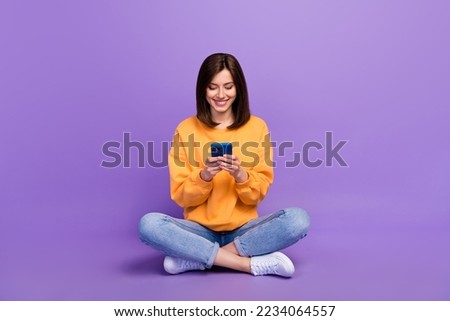 Full body size photo of young positive entrepreneur using new smartphone excited watching youtube video online new update isolated on violet color background