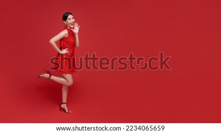 Asian woman wearing traditional cheongsam qipao dress shocked surprised wow with copy space isolated on red background. Happy Chinese new year