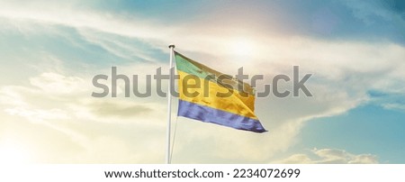Gabon national flag waving in beautiful sky.