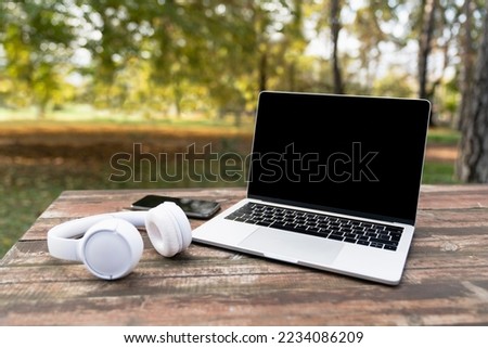laptop in the park on wooden table