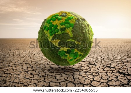 Green planet earth on desert. Symbol of global warming and climate change Royalty-Free Stock Photo #2234086535