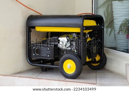 Portable electric generator running in the cold winter.Energy genocide. Power outage as a result of missile strikes by Russia on energy facilities of Ukraine. Small business use gasoline generators Royalty-Free Stock Photo #2234103499