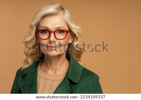 Studio portrait of confident mature businesswoman wearing stylish red  eyeglasses isolated on background. Successful business concept   Royalty-Free Stock Photo #2234109337