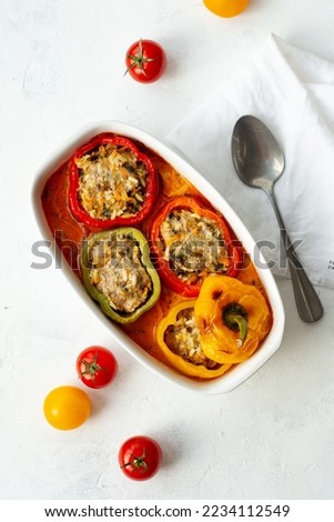Baked bell pepper with meat and rice in a ceramic bowl on a light background. Stuffed pepper, halves of peppers stuffed with meat and rice, biber dolmasi Royalty-Free Stock Photo #2234112549