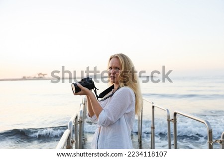 Photographer, woman and camera at beach for travel vacation or holiday in summer sun.