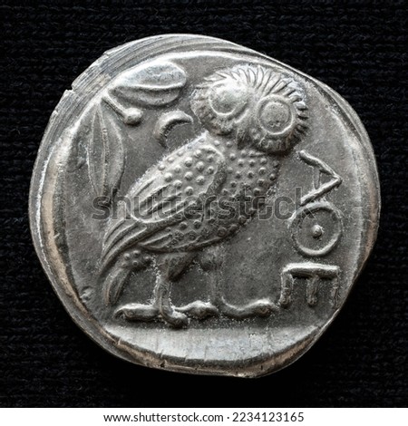Ancient Greek coin showing owl and inscription Athens. Old money, silver tetradrachm isolated on black background, macro. Concept of Greece, vintage coin, owl in civilization, retro artifact, history