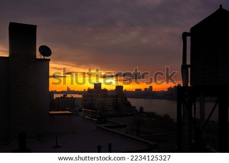 Rooftop view of dusk along the Hudson River,  Manhattan in foreground, New Jersey across the Hudson