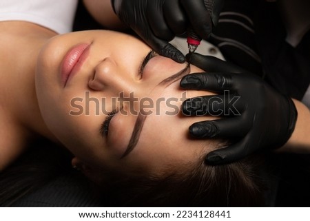 Process of creating permanent brow makeup with a machine at beauty salon. Top view Royalty-Free Stock Photo #2234128441