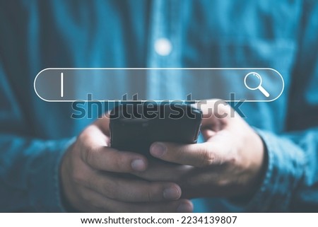 Businessman using smartphone to input alphabet in searching bar for Search Engine Optimisation or SEO concept to find information by internet connection.