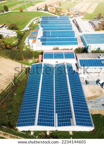 Solar panels covering the roof tops of industrial buildings in the country side