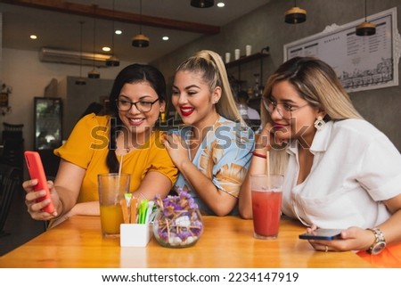 Three friends watching the cell phone sitting in a bar