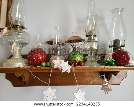 A shelf with festive ornaments and old lanterns setup on it.
