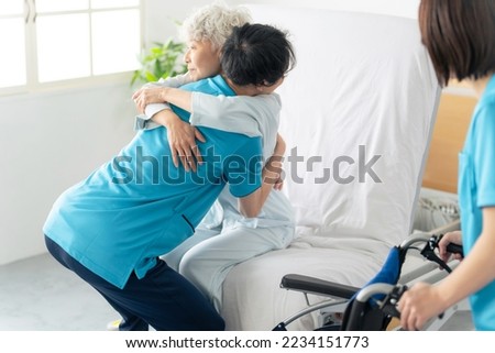 A caregiver transferring an elderly person from a nursing bed to a wheelchair. Royalty-Free Stock Photo #2234151773