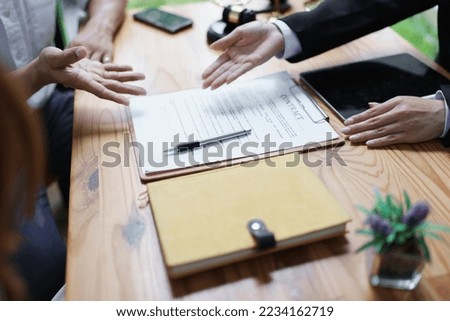 Lawyer hands important documents to couple to sign.