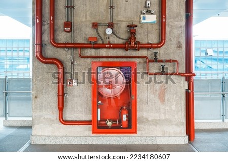 Fire extinguisher and water pump system on the wall, powerful emergency equipment for apartment and hotel Royalty-Free Stock Photo #2234180607