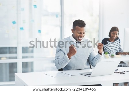 Always remember that todays accomplishments were yesterdays impossibilities. Shot of a young businessman celebrating at his office desk with a colleague working in the background. Royalty-Free Stock Photo #2234189455