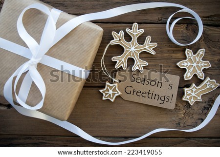 A Natural Looking Gift with white Decorated Ginger Bread Cookies and a brown Label with Season's Greetings on it