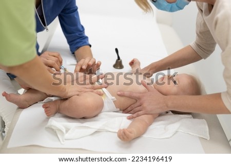 Baby beeing vaccinated by pediatrician in presence of his mother. Preventive vaccination against Diphtheria, whooping cough, tetanus, hepatitis, haemophilus influenzae, pneumococcus, poliomyelitis.