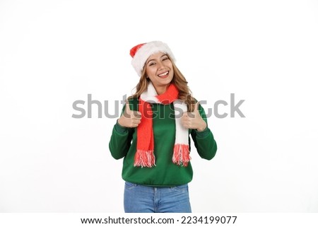Attractive excited asian female in green sweater with santa hat on christmas isolated on white background. Thumb up