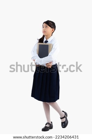 Asian schoolgirl student in uniform holding book walking full length white background.
