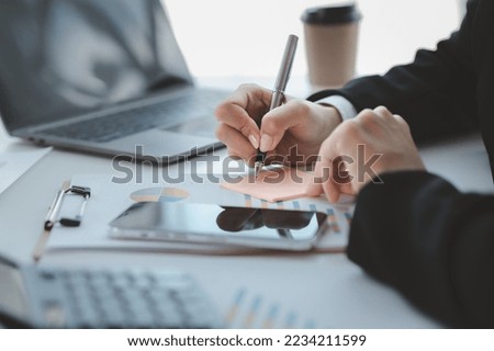 Businessman check to financial documents, he owns a startup company, he sits checking the company's financial summary prepared by the finance department. Management concept of startup company.