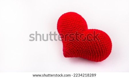 Knitted red heart on white background. Red heart copy space