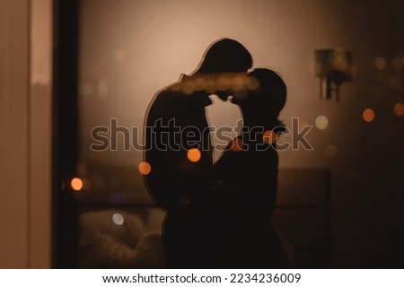 Reflection in the window couple in love kissing with lights in the background, romantic night in the hotel concept Royalty-Free Stock Photo #2234236009