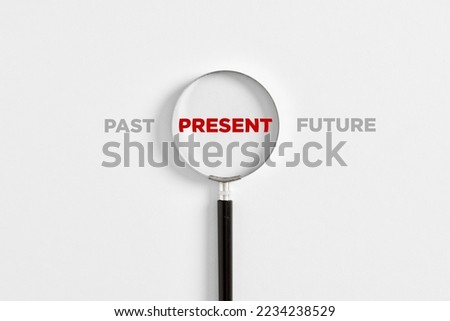 Focusing on the current situation, positive thinking and mindset concept. Magnifying glass on the word present with the words past and future. Royalty-Free Stock Photo #2234238529