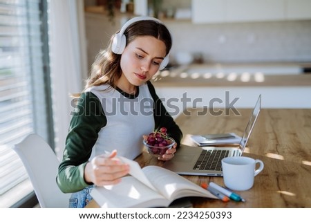 Young woman having distance education in her apartment.