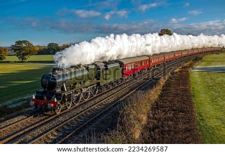 Steam locomotive pump out clouds of white smoke. Steam train with white smoke. Steam train on railway. Vintage steam train ride Royalty-Free Stock Photo #2234269587