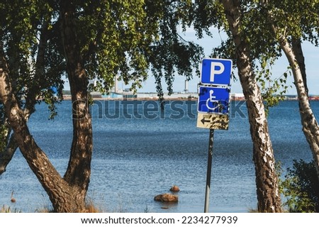 Reserved disabled parking space sign at Kattegat sea shoreline in Halmstad, Sweden. Selective focus.