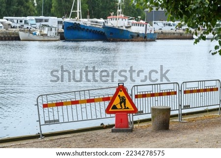 Road works sign on Nissan river promenade in Halmstad, Sweden. Selective focus.
